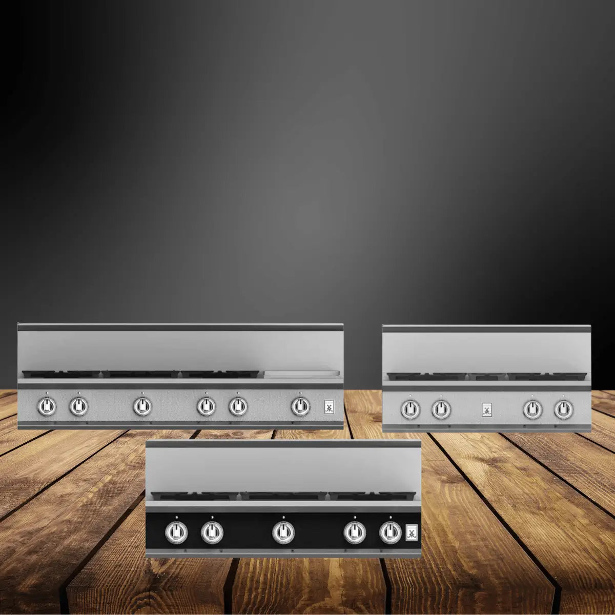 Commercial rangetops collection featuring stainless steel gas cooktops with multiple burners and front control knobs, designed for professional kitchens and displayed on a wooden surface.